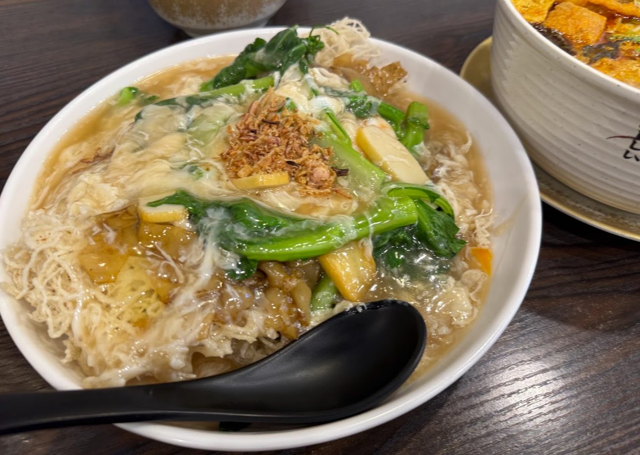 A nest of very fine crisp-fried noodles softening under a thick gravy with ribbons of egg, choy sum, pale yellow slices and fried shallots